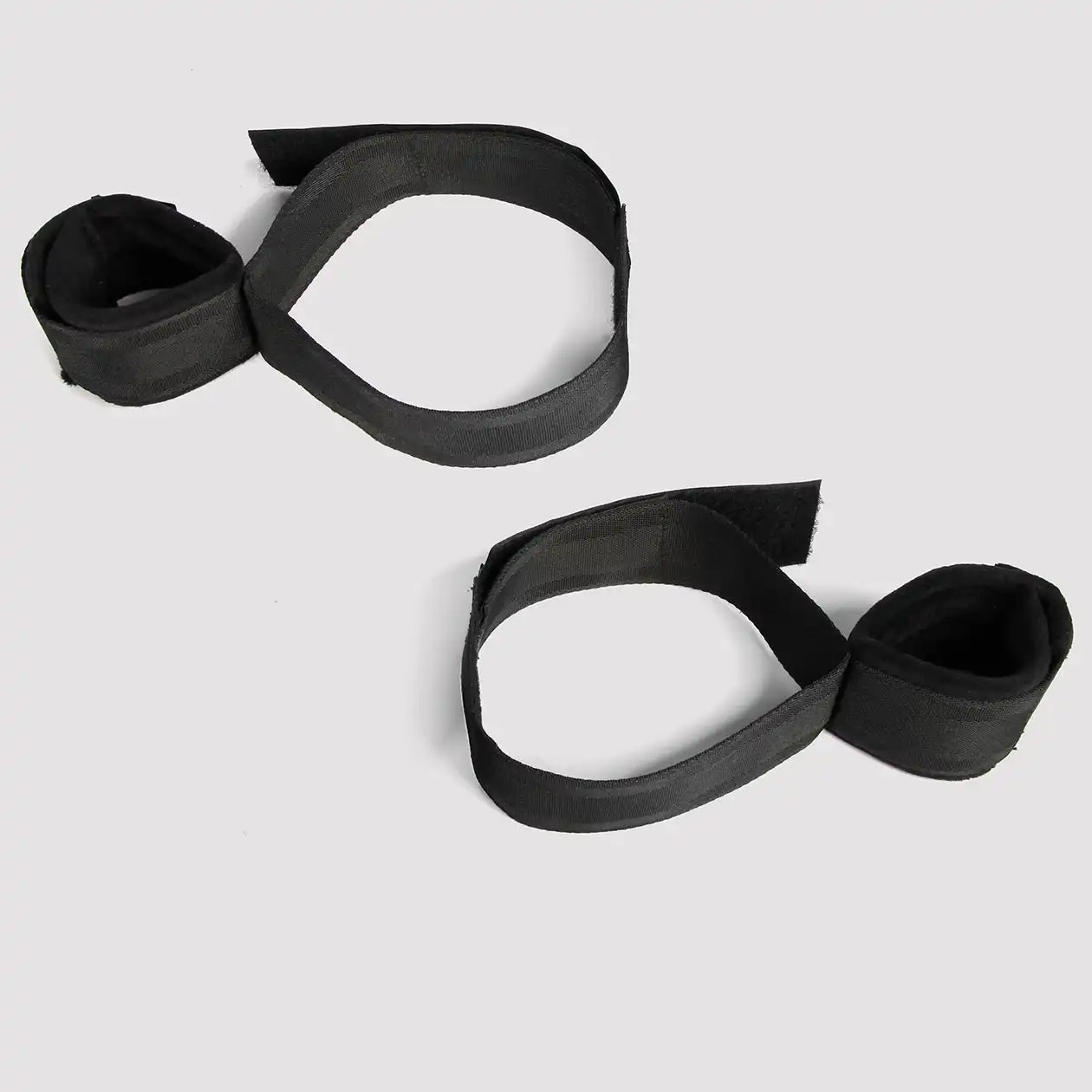 Black wrist-to-thigh restraint set with adjustable wrist cuffs and thigh straps connected by nylon webbing.