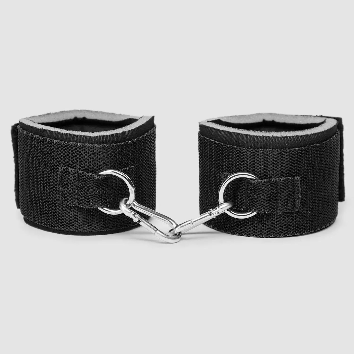 Black wrist-to-waist restraint set with adjustable waist belt, padded wrist cuffs, and metal clip connectors.