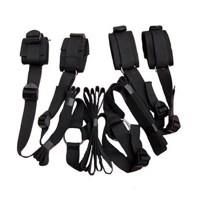 Black adjustable bed restraint kit with under-mattress anchor system and four padded restraint cuffs.
