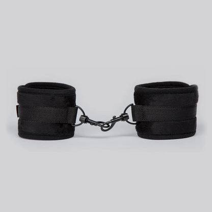 Adjustable black ankle cuffs with soft padding and metal lock connector between the cuffs.