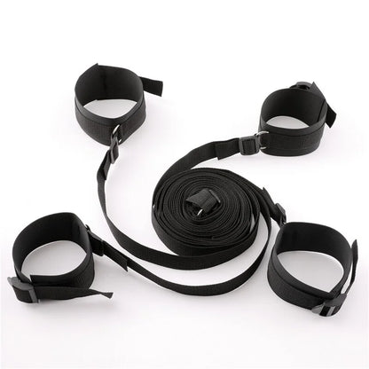Black adjustable bed restraint kit with under-mattress anchor system and four padded restraint cuffs.
