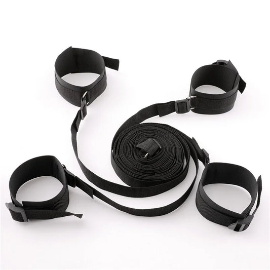 Black adjustable bed restraint kit with under-mattress anchor system and four padded restraint cuffs.
