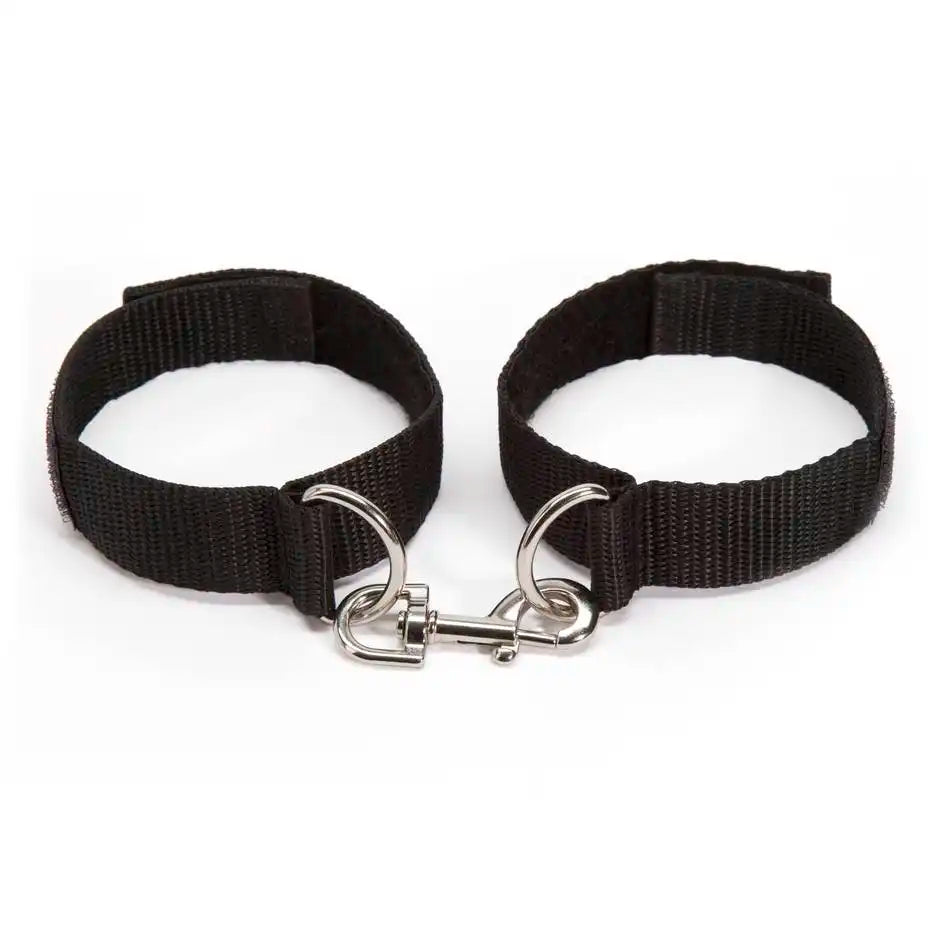 Adjustable wrist handcuff pair with metal lock connector and nylon straps.