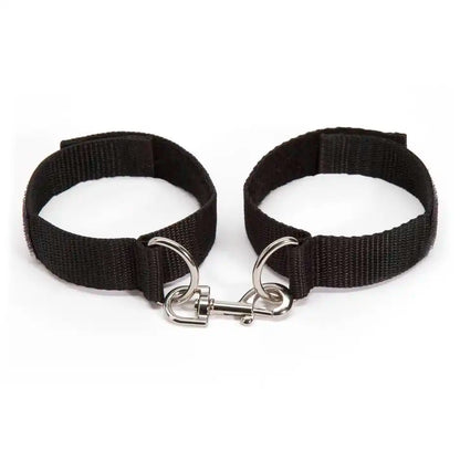 Adjustable wrist handcuff pair with metal lock connector and nylon straps.