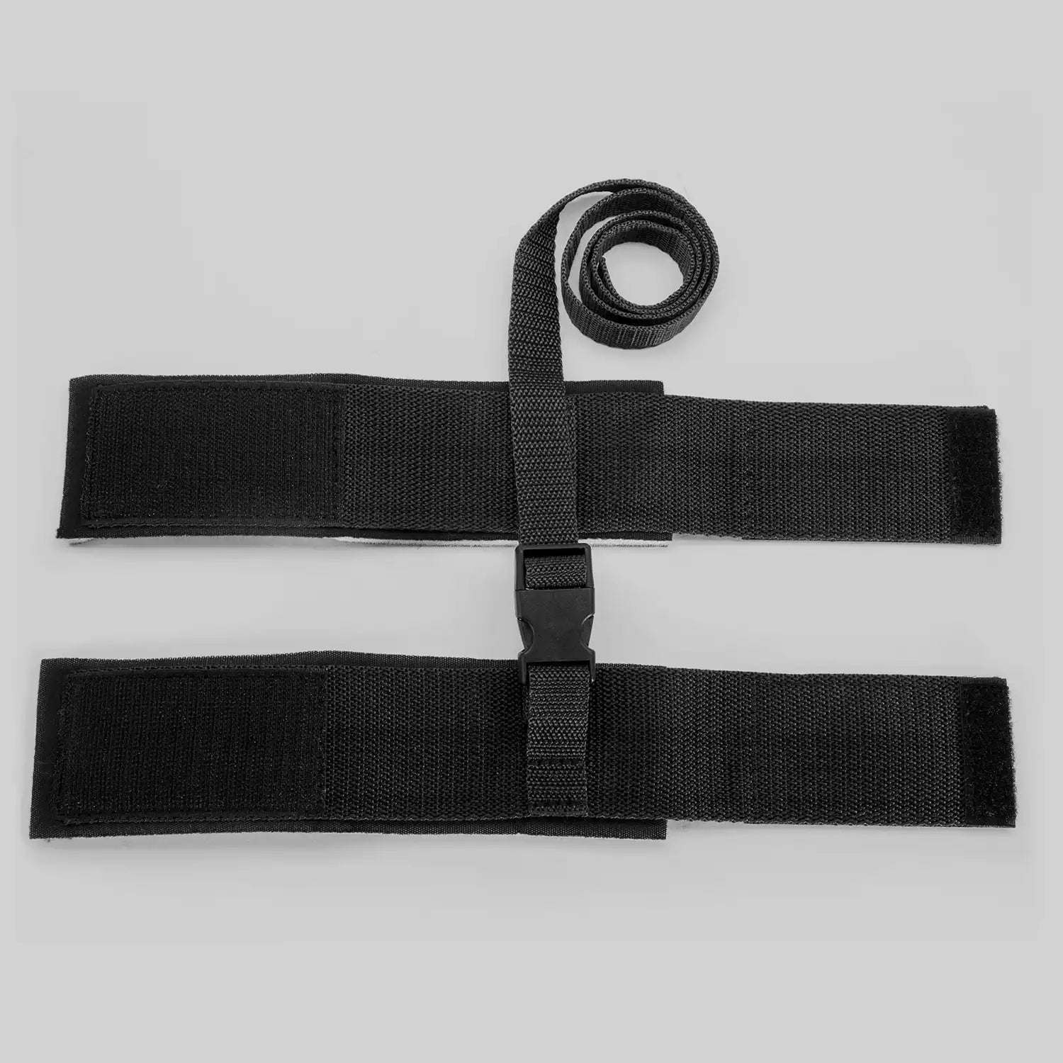 Adjustable wrist restraint cuffs connected with a quick-release buckle and soft padded lining.