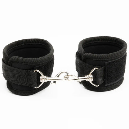 Pair of adjustable padded wrist restraint cuffs connected with a metal lock connector.
