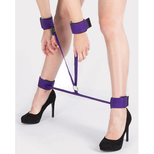 Purple wrist and ankle restraint set with adjustable straps and central metal ring.
