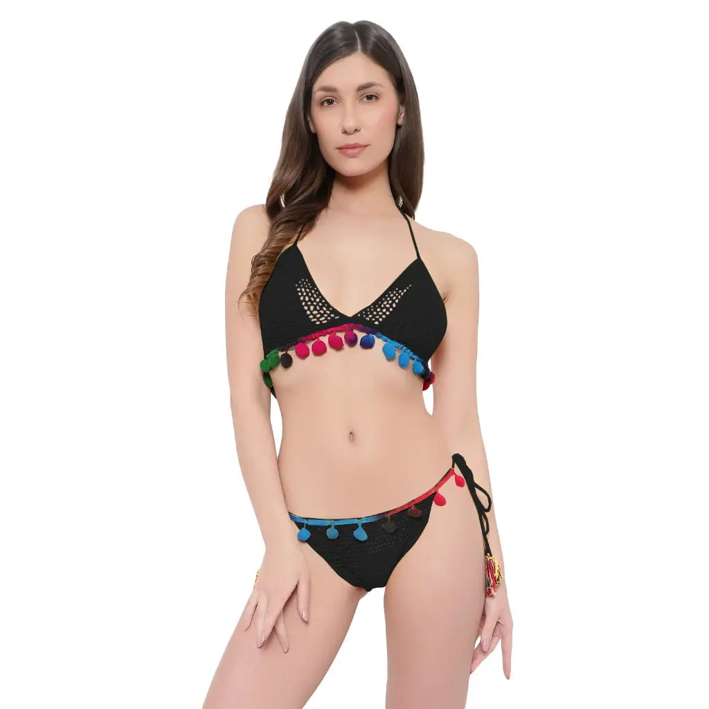 Handmade crochet bikini set with pom-pom detailing and tie side beachwear styling.