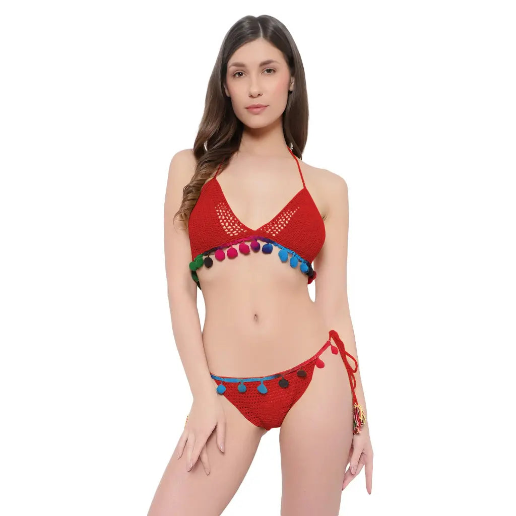 Handmade crochet bikini set with pom-pom detailing and tie side beachwear styling.