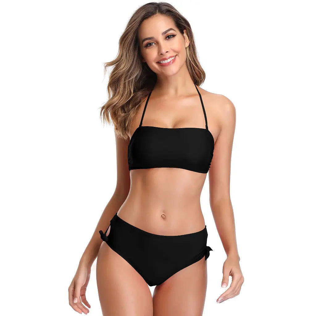 woman wearing elegant black bandeau bikini swimwear set with side tie bottoms and minimalist beach fashion style
