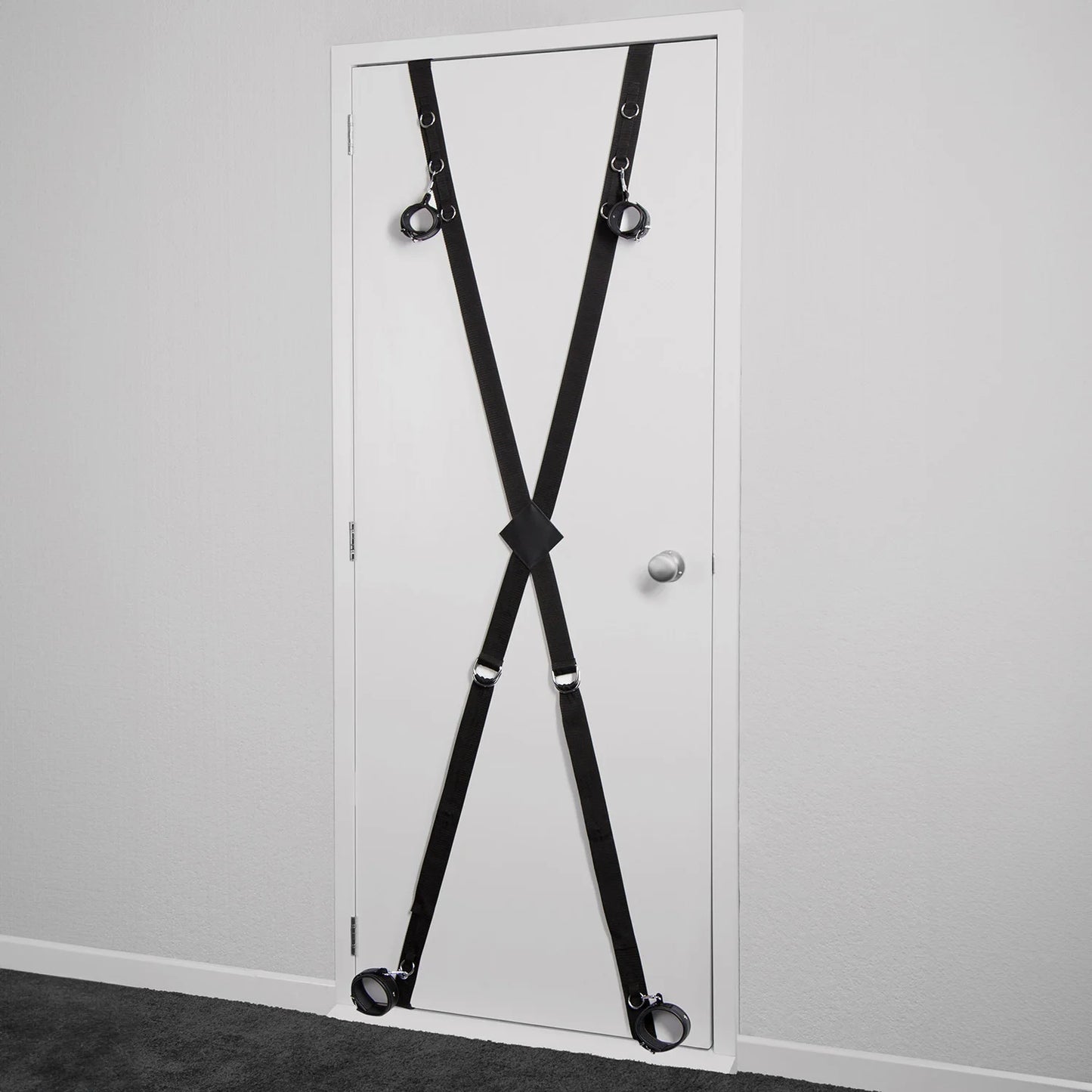 Over-the-door full restraint kit with adjustable wrist and ankle cuffs attached to a door-mounted strap system.
