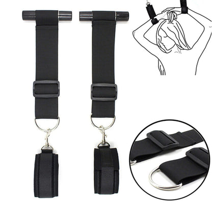 Black over-the-door restraint kit with adjustable straps and padded wrist cuffs attached to a door anchor system.
