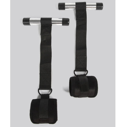 Black over-the-door restraint kit with adjustable straps and padded wrist cuffs attached to a door anchor system.