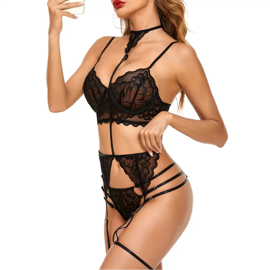 women's black multi-piece lingerie set featuring an underwired lace bustier with choker harness, matching garter belt, and strappy panties.
