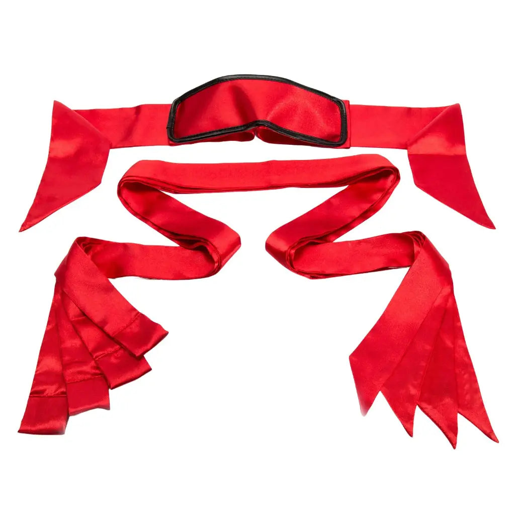 Satin bed restraint kit with blindfold, adjustable wrist cuffs, ankle restraints, and under-mattress straps.
