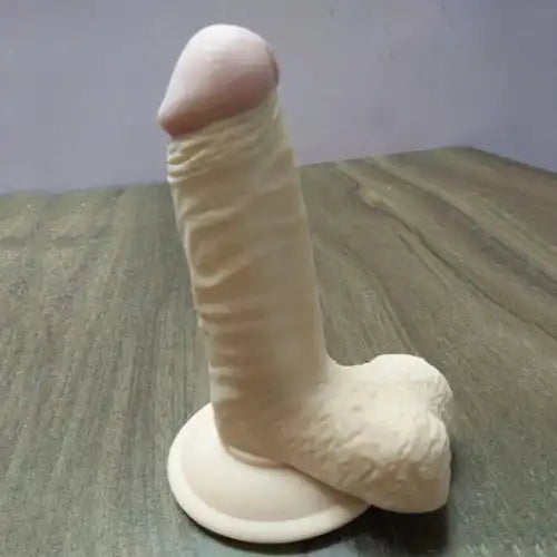 Realistic silicone massager for women with suction base and flexible body-safe silicone construction.