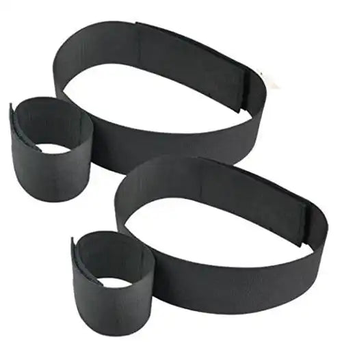 Black wrist-to-thigh position restraint strap with adjustable wrist cuffs and leg positioning straps.