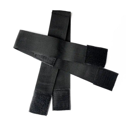 Black wrist-to-thigh position restraint strap with adjustable wrist cuffs and leg positioning straps.