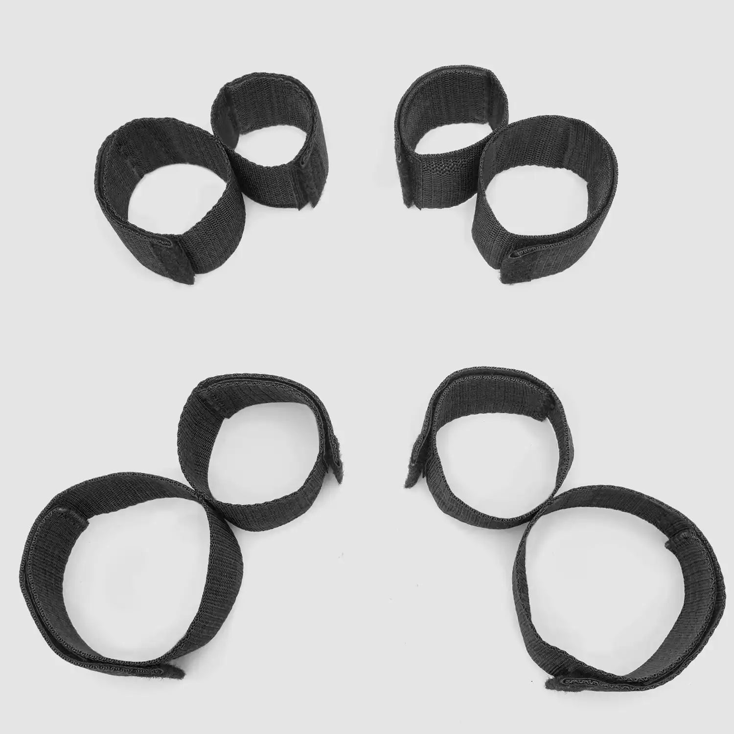 Black wrist-to-ankle restraint set with adjustable wrist cuffs and ankle straps connected through durable nylon webbing.
